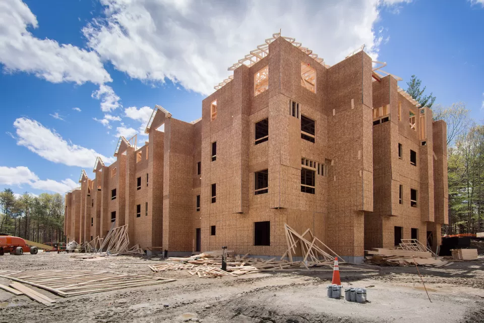 Wood-framed four-story building under construction.